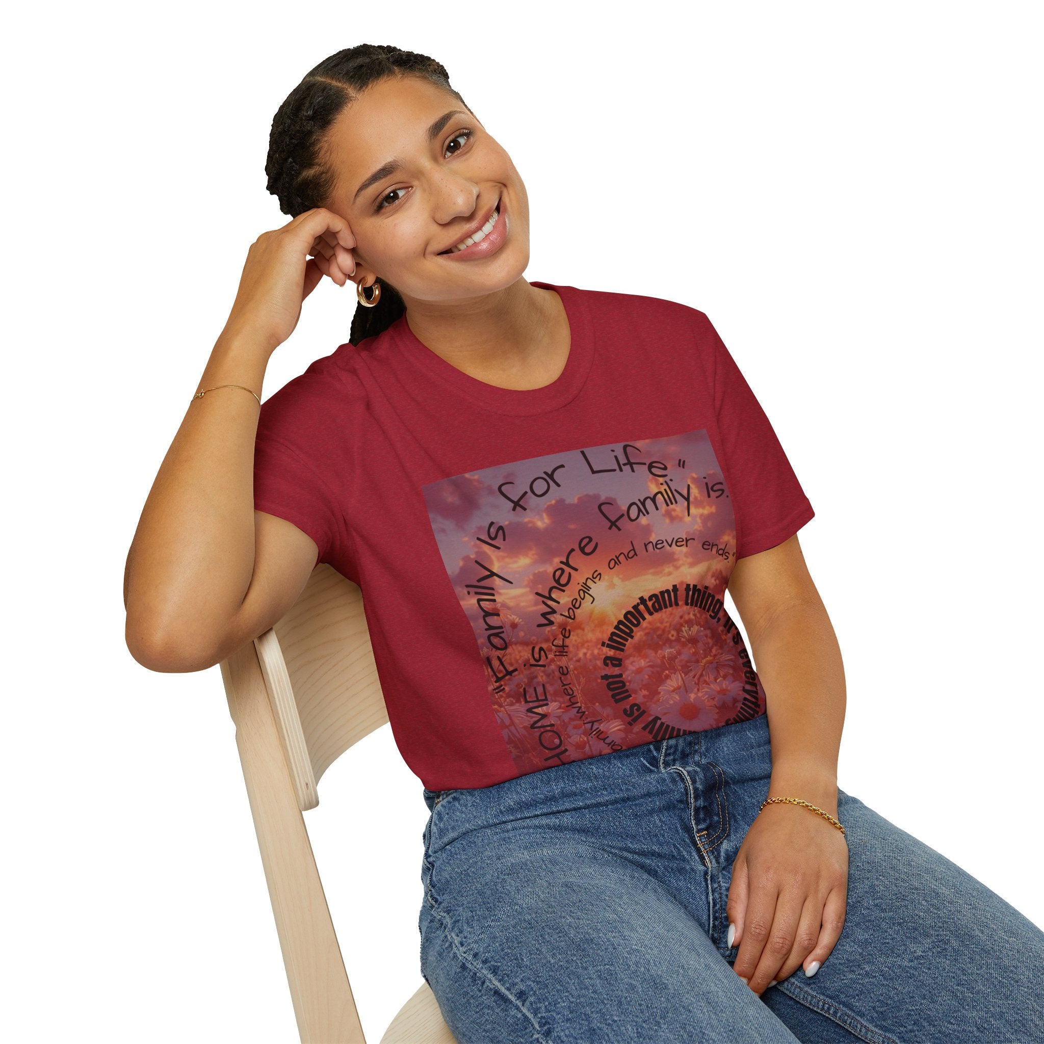 Woman wearing a red t-shirt with a graphic design sitting on a chair.