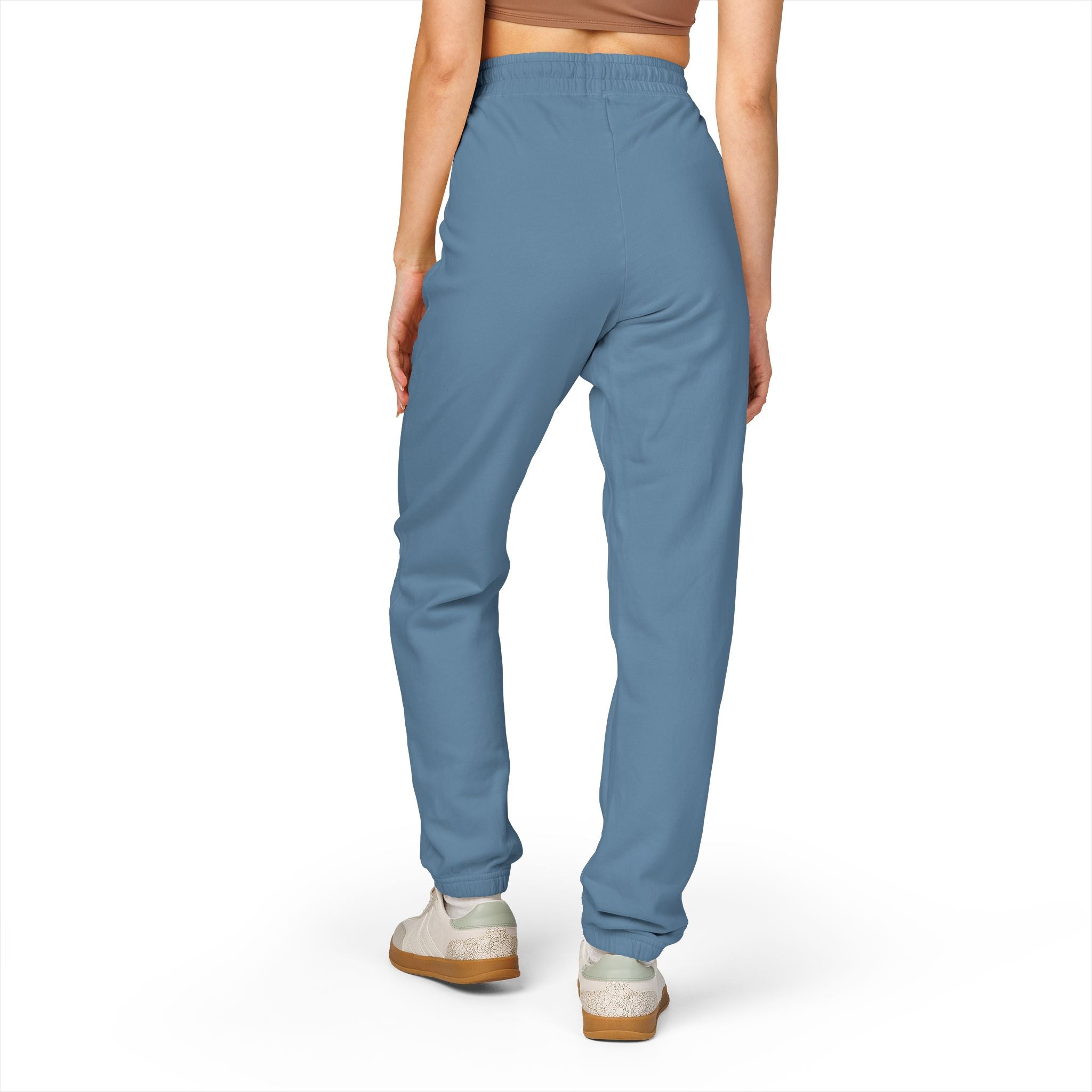 Blue jogger pants worn by a person on a white background