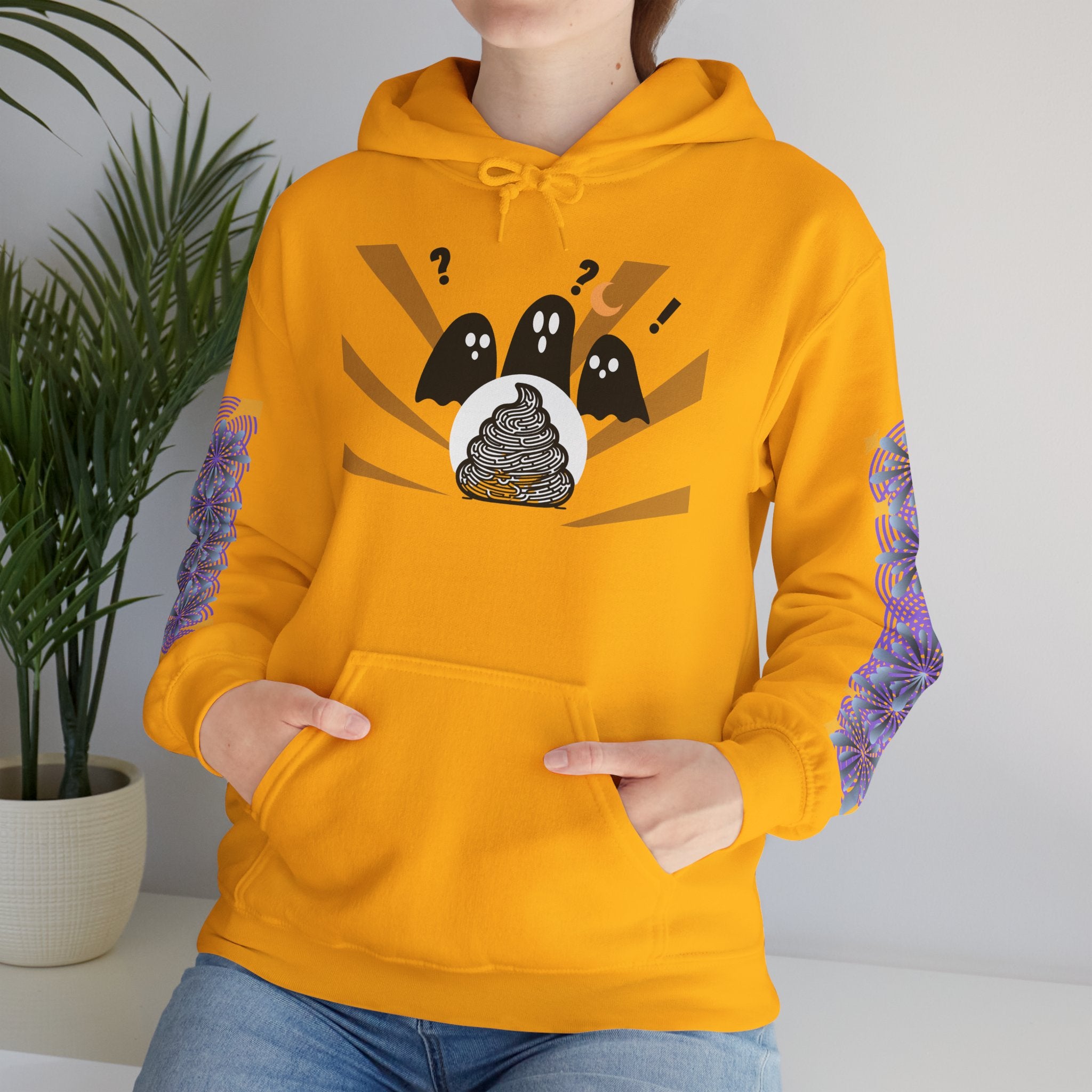 Person wearing a mustard yellow hoodie with a graphic design of ghosts and a poop emoji.