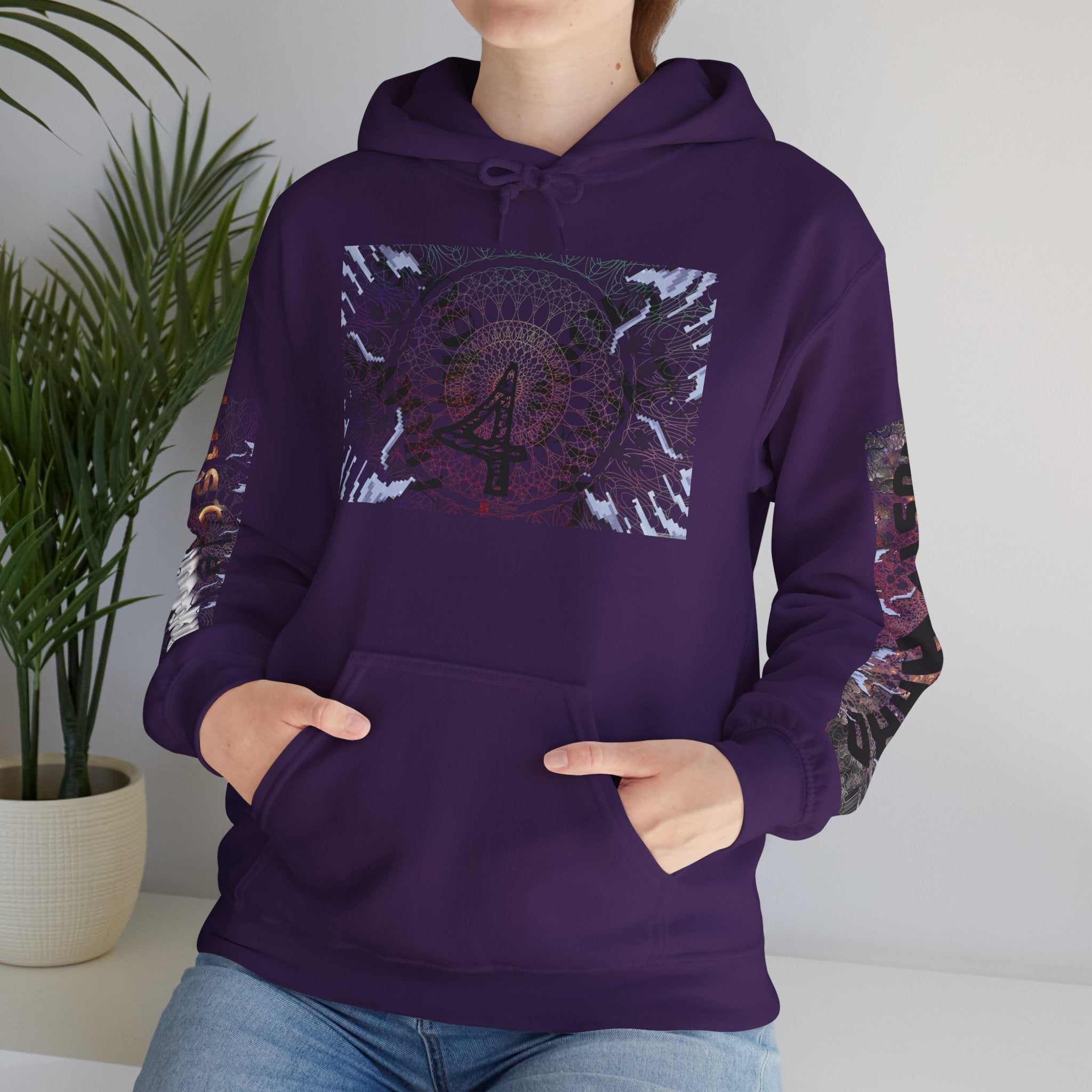 Person wearing a purple hoodie with a colorful design, standing indoors next to a plant.