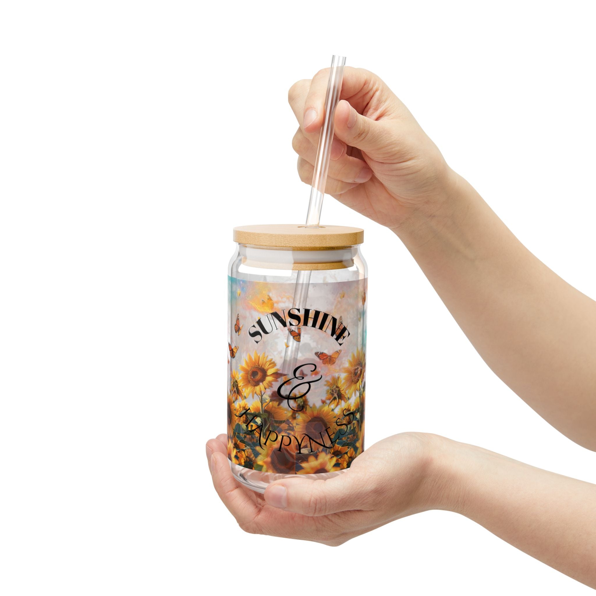 Hand holding a tumbler with sunflower design and 'Sunshine & Happiness' text on a white background