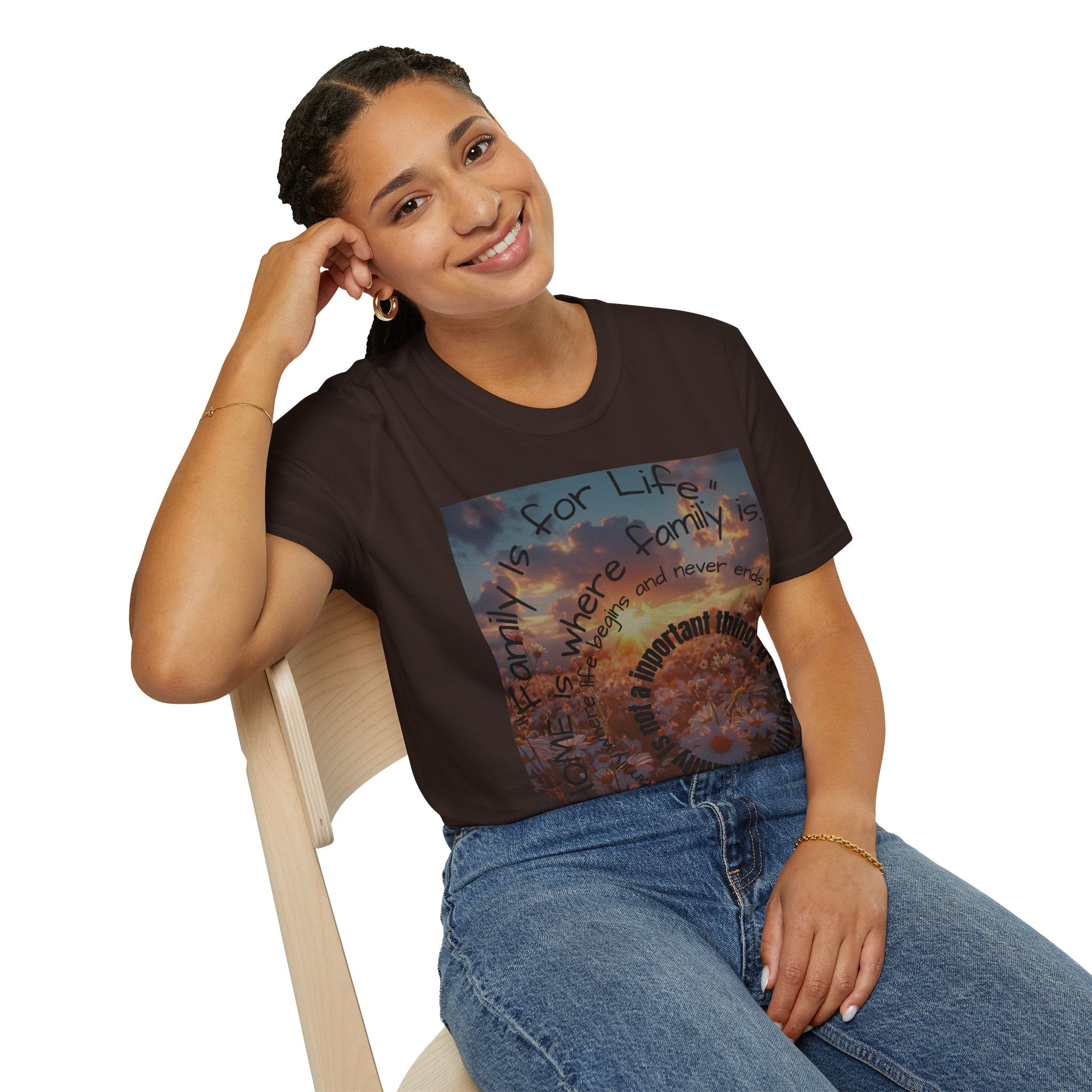 Woman wearing a brown t-shirt with a graphic design sitting on a chair.