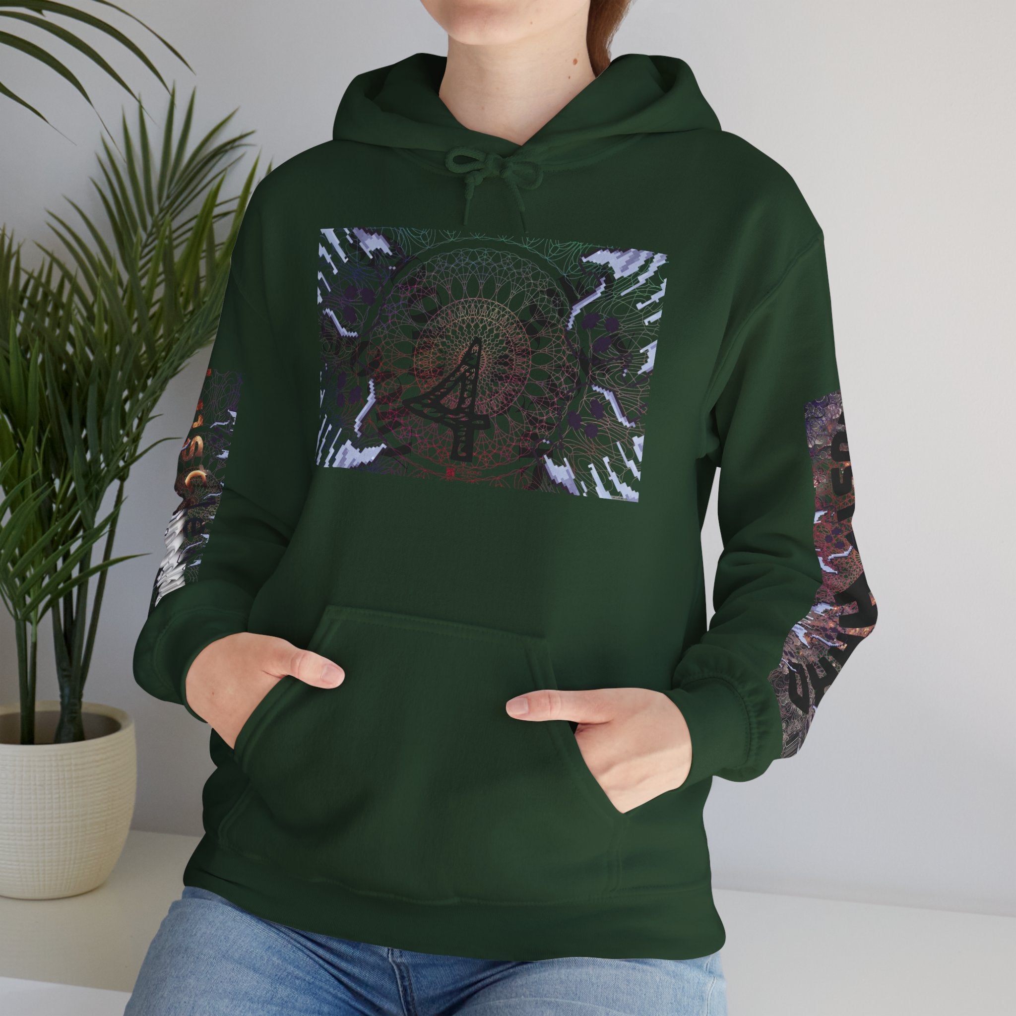 Person wearing a green hoodie with a colorful design, standing indoors next to a plant.