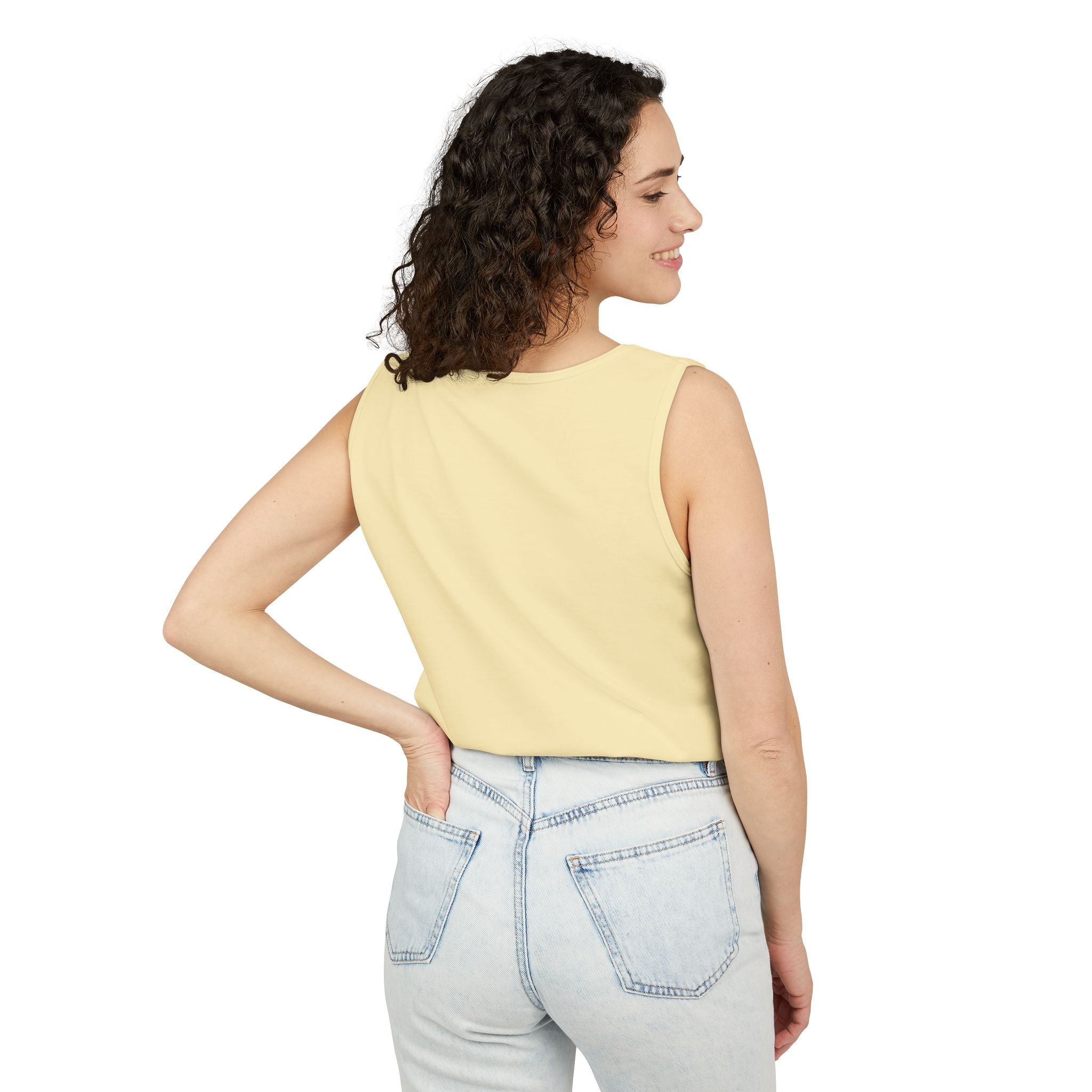 Woman wearing a yellow sleeveless top and light blue jeans on a white background