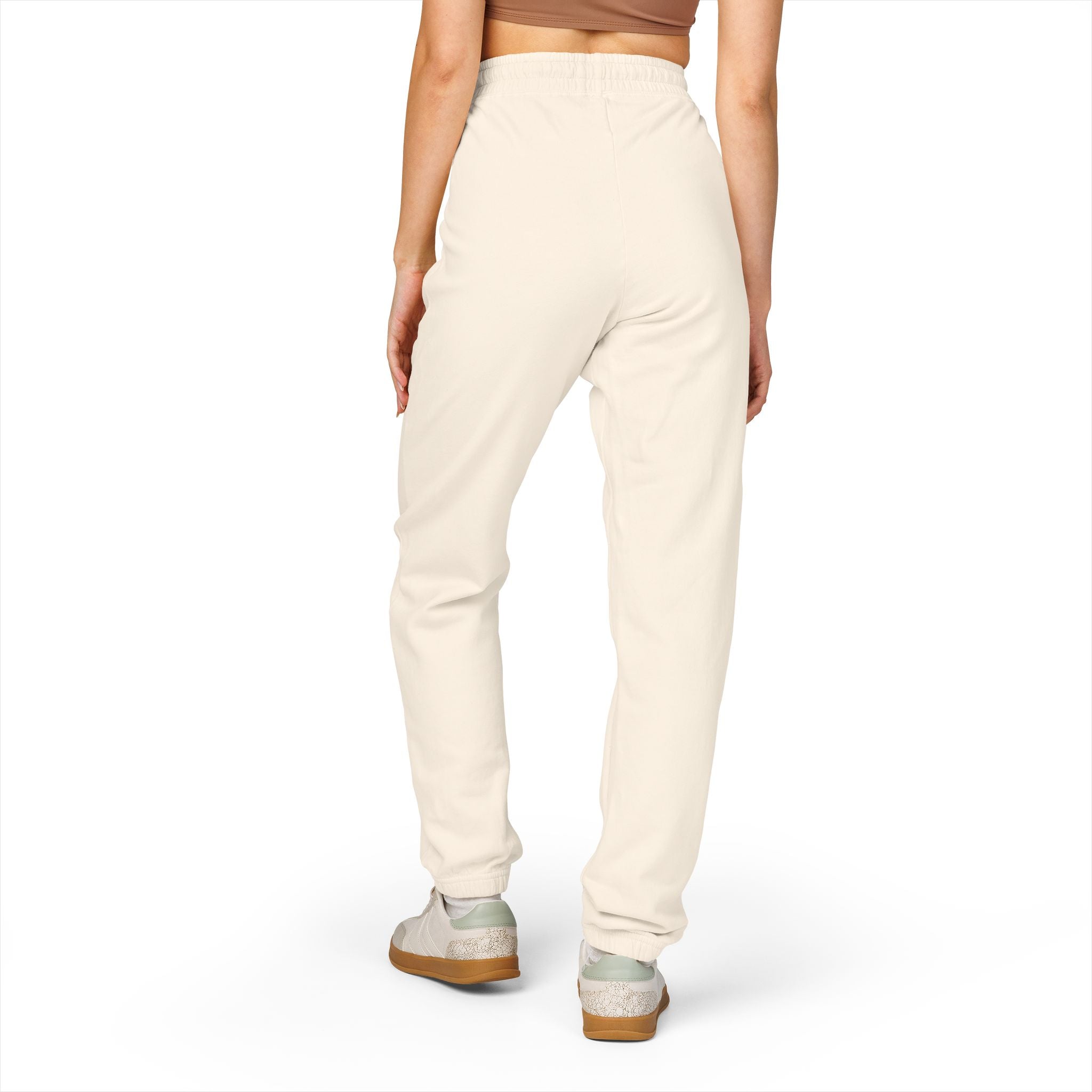 Person wearing cream-colored jogger pants on a white background