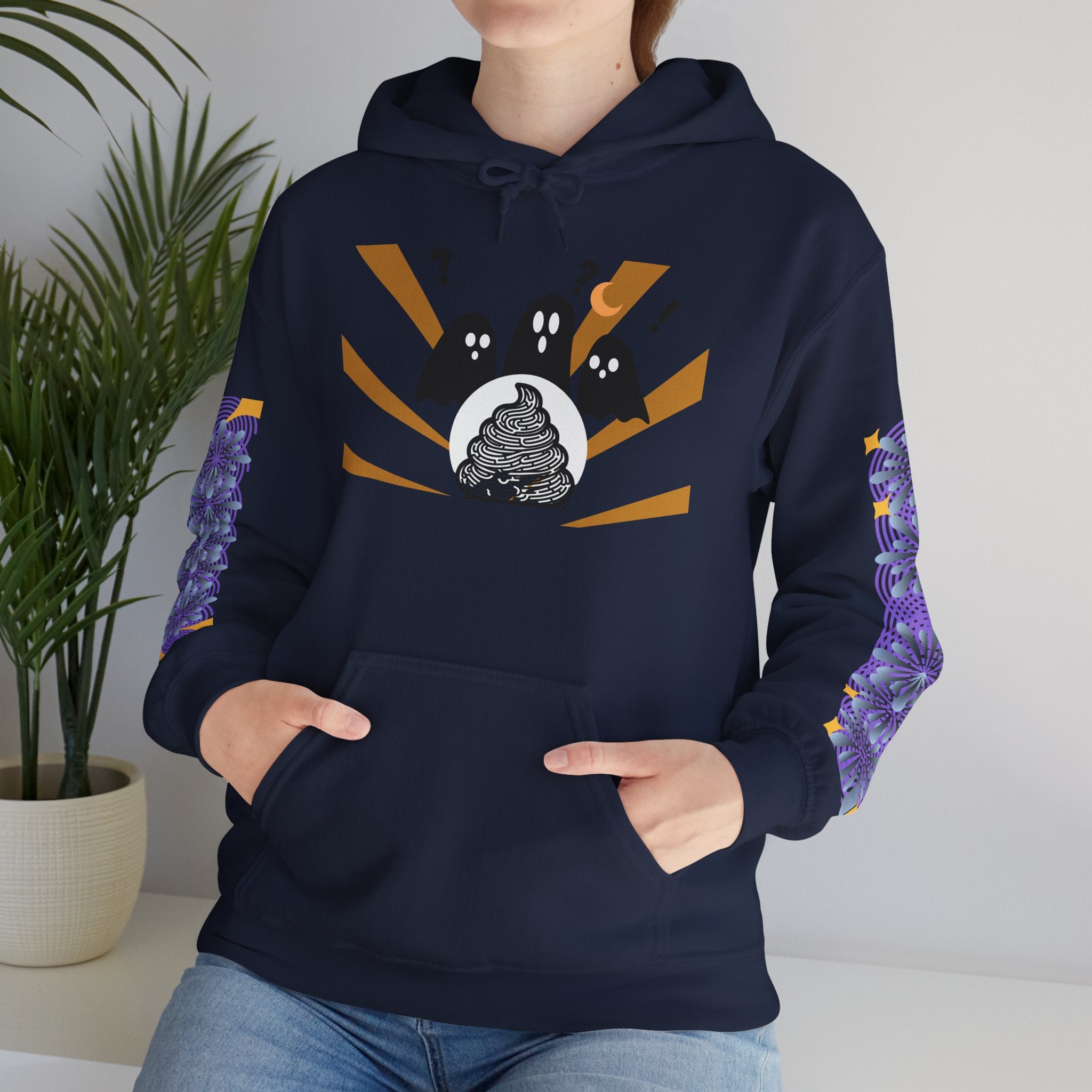 Person wearing a navy blue hoodie with a graphic design, standing indoors next to a plant.