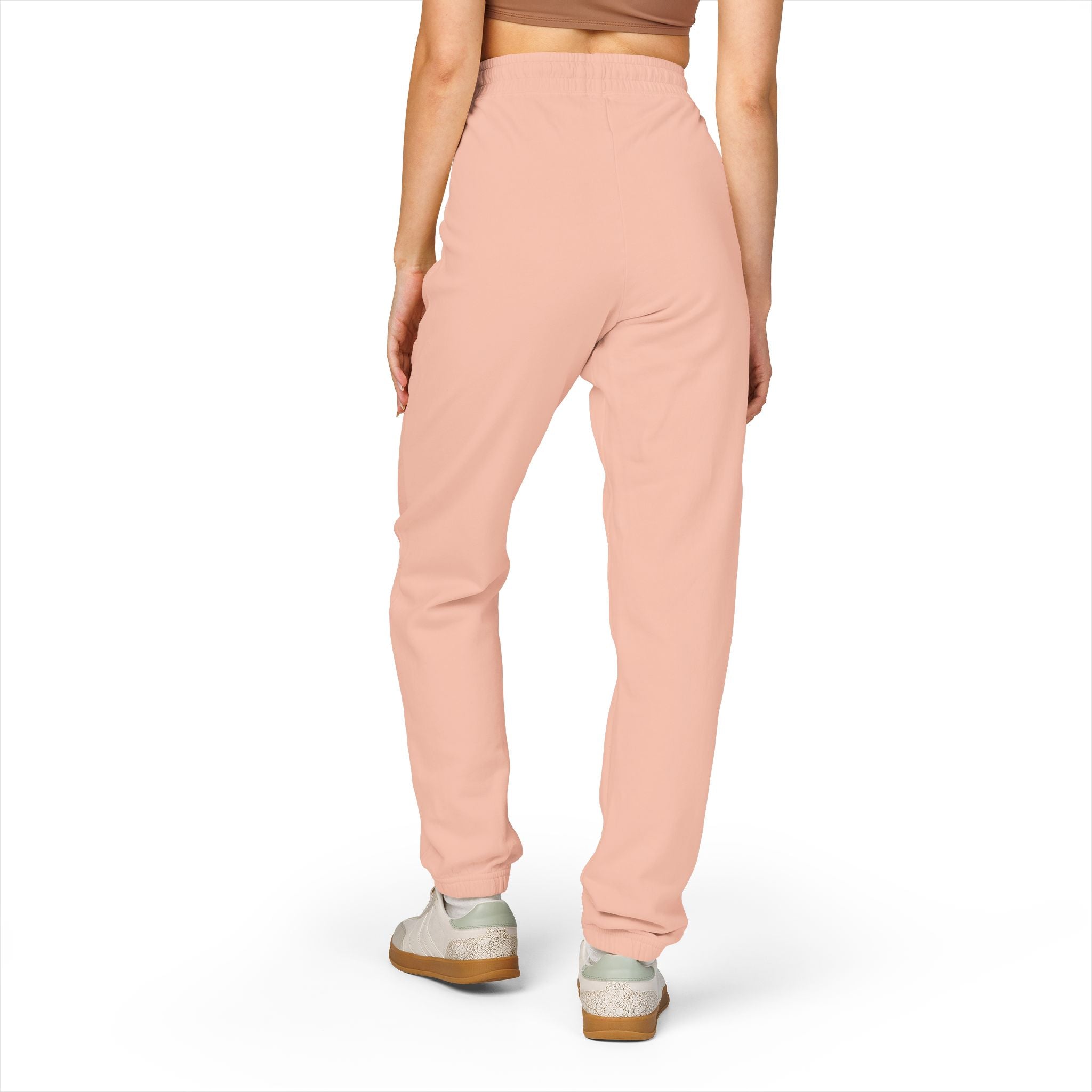 Person wearing light pink sweatpants on a white background